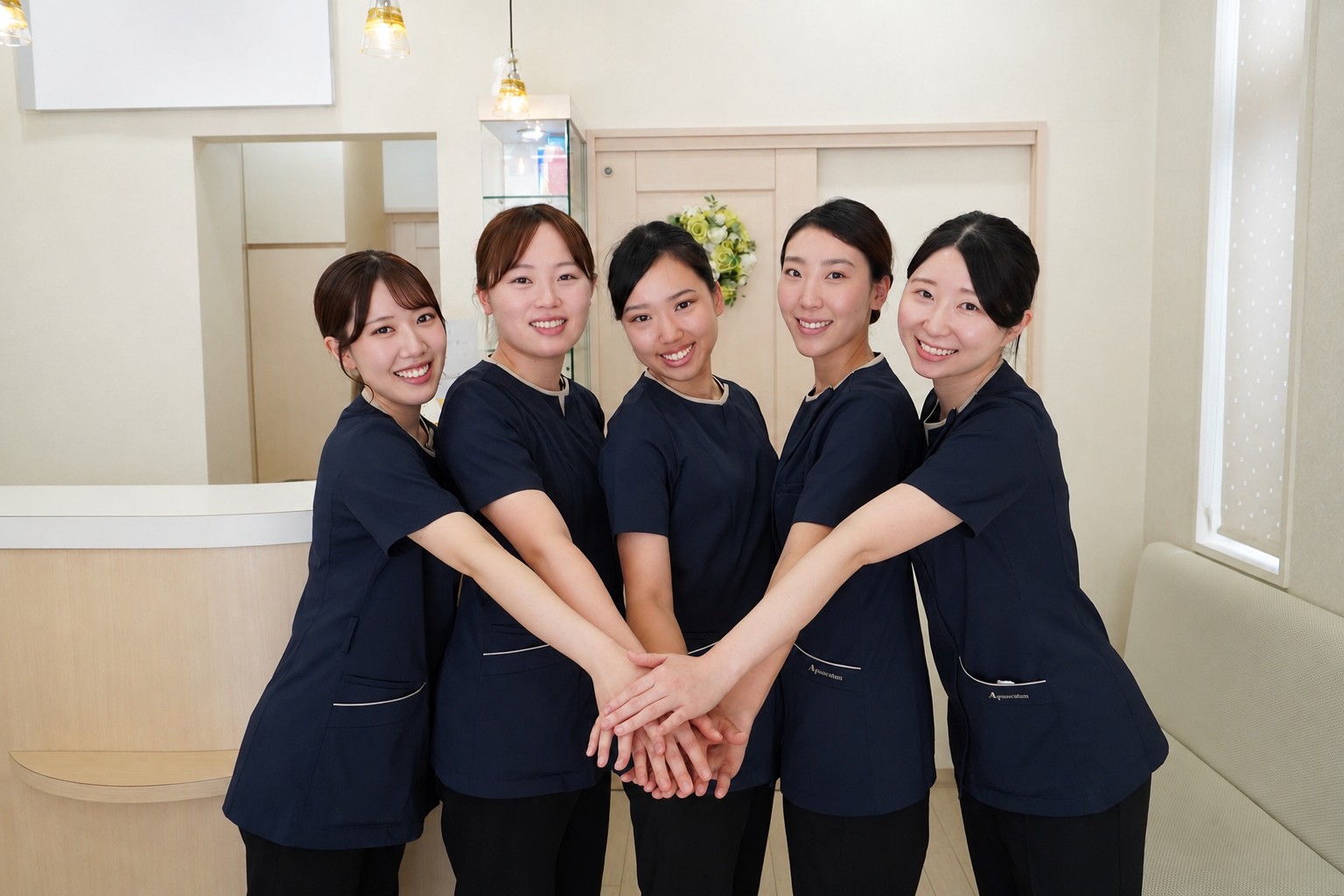 スタッフ全員で手を重ね合うチームワークの様子